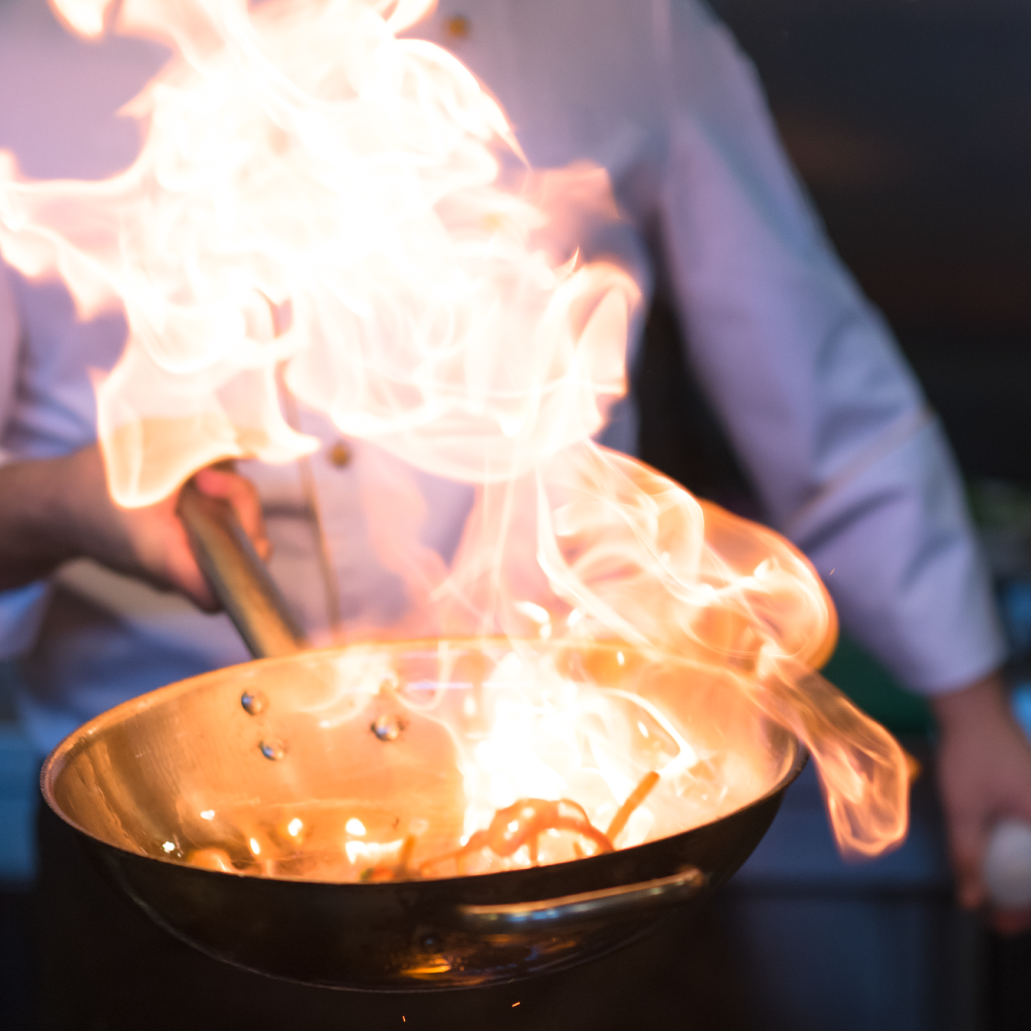 Chef handling a pan on fire